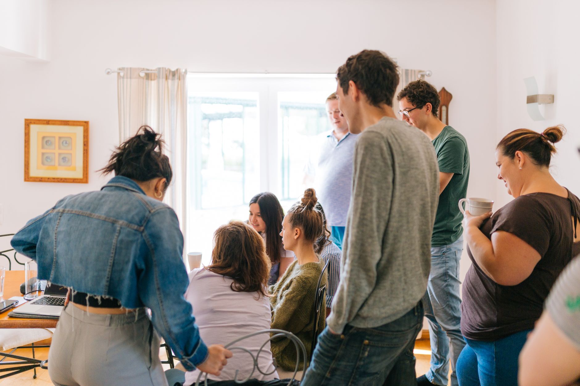 A group of adults collaborating around a table in a bright room, promoting teamwork and creativity.
